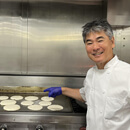 Chef Roy Yamaguchi flipping P?alua Pancakes at Kapi?olani CC
